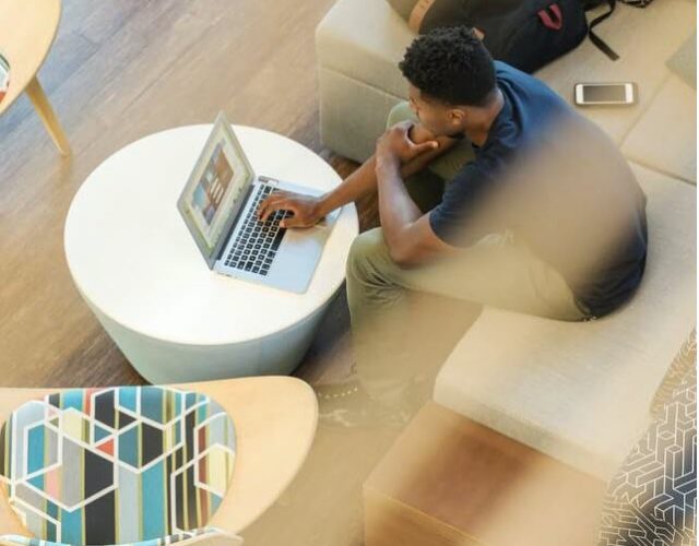 Man on a Couch with laptop on coffee table